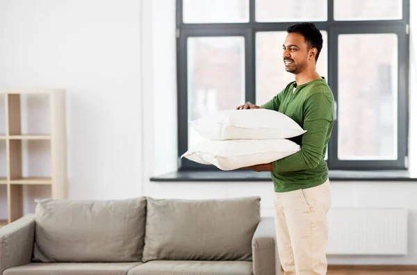 Homem indiano feliz segurando travesseiros em casa — Fotografia de Stock