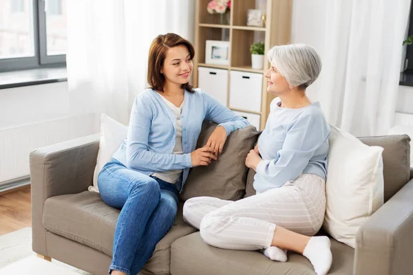 Senior moeder praat met volwassen dochter thuis — Stockfoto