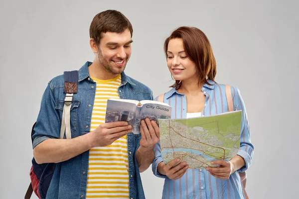 Feliz casal de turistas com guia da cidade e mapa Fotografias De Stock Royalty-Free