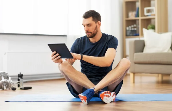 집에서 운동 매트에 태블릿 컴퓨터와 남자 — 스톡 사진