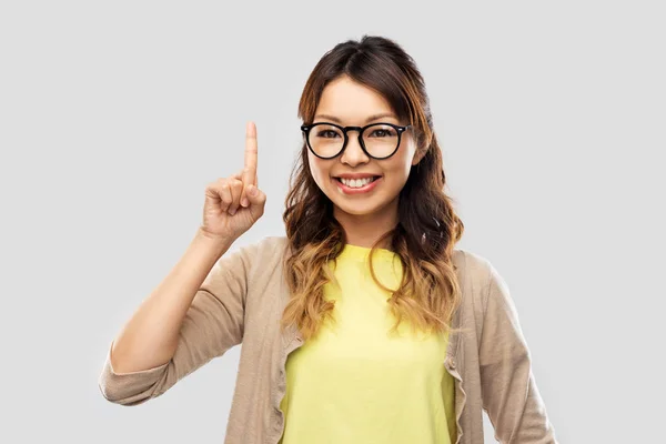 Mujer asiática en gafas o estudiante con el dedo arriba — Foto de Stock