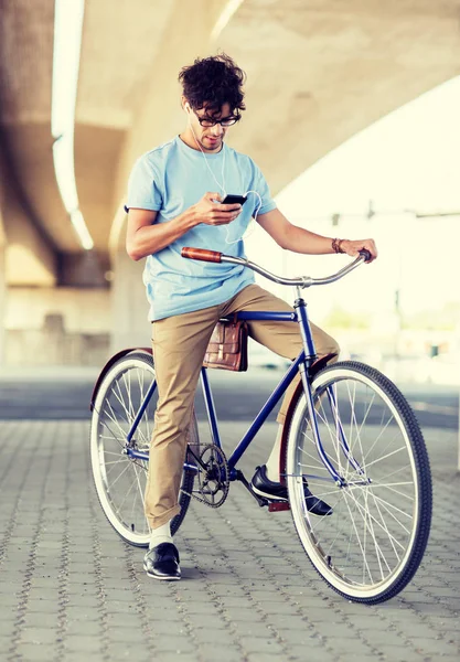 Hombre con smartphone y auriculares en bicicleta —  Fotos de Stock