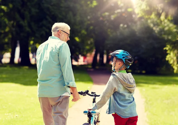 Grootvader en jongen met fiets in zomer park — Stockfoto