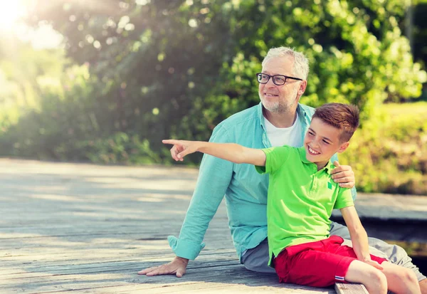 Abuelo y nieto sentado en la litera del río —  Fotos de Stock