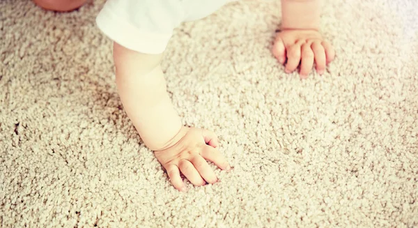 Hands of baby crawling on floor or carpet — Stock Photo, Image