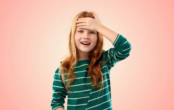 Sorrindo menina de cabelos vermelhos segurando em sua cabeça — Fotografia de Stock