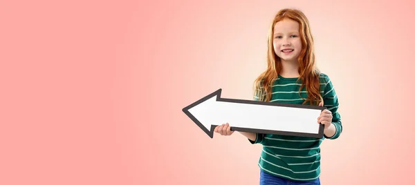 Smiling red haired girl with arrow showing to left — Stock Photo, Image
