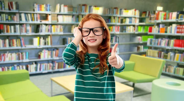 红头发的学生女孩在图书馆戴眼镜 — 图库照片