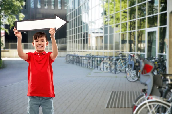 Boy holding big white rightwards thick arrow — Stock Photo, Image
