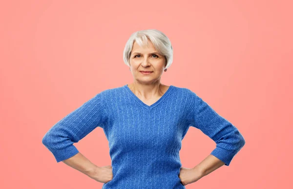 Donna anziana in maglione blu mani sui fianchi — Foto Stock