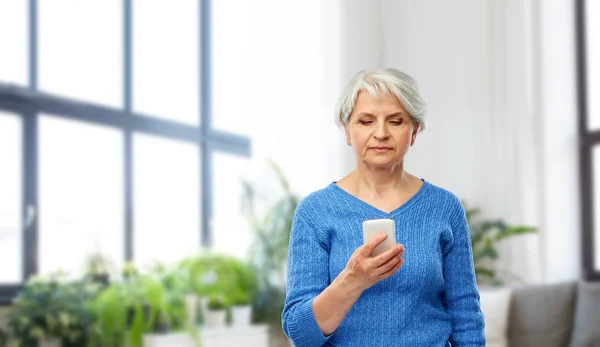 Donna anziana utilizzando smartphone a casa — Foto Stock