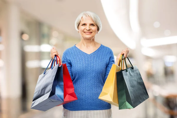 Mujer mayor con bolsas de compras sobre el centro comercial —  Fotos de Stock