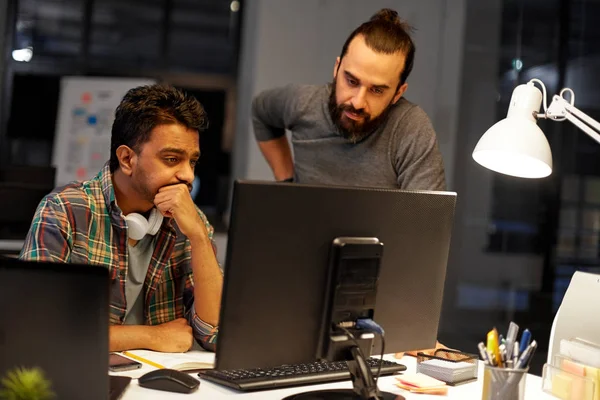 Equipe criativa com computador trabalhando até tarde no escritório — Fotografia de Stock