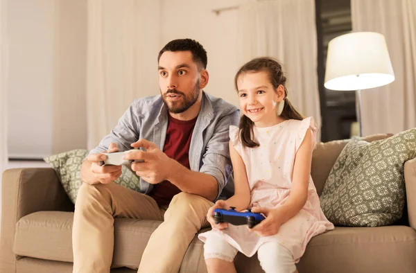 Vader en dochter afspelen van video game thuis — Stockfoto