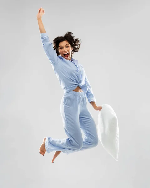 青いパジャマで幸せな女性は枕でジャンプ — ストック写真