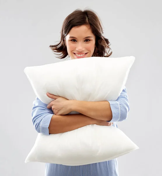 Щаслива молода жінка в піжамі обіймає подушку — стокове фото