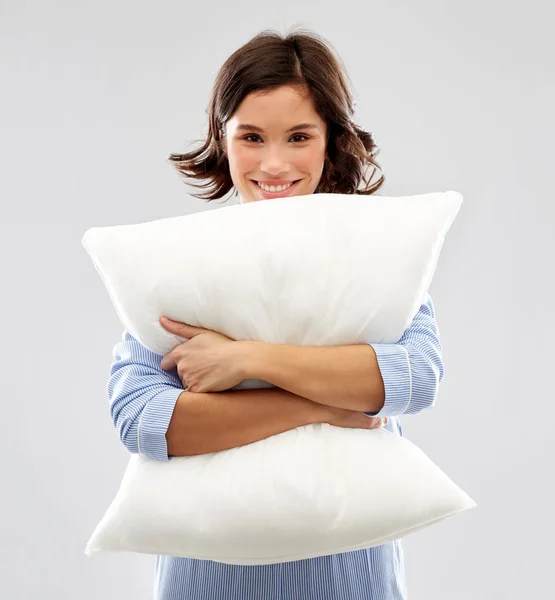 Happy young woman in pajama hugging pillow Stock Photo