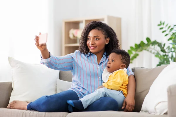 Afrikaanse moeder met baby zoon het nemen van selfie thuis — Stockfoto