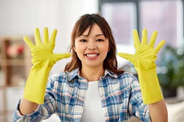 Asiatisk kvinne med gummihansker som vasker hjemme – stockfoto