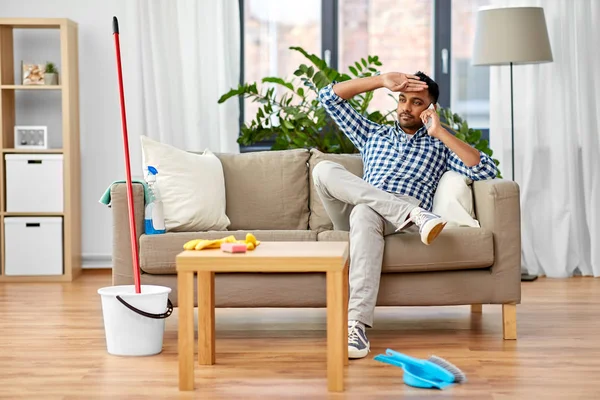 Adam ev temizliği nden sonra akıllı telefon çağırıyor — Stok fotoğraf