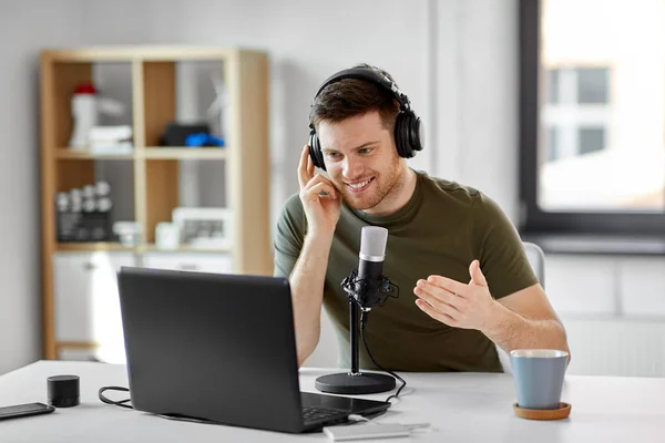 Homme avec ordinateur portable et microphone au bureau à domicile — Photo