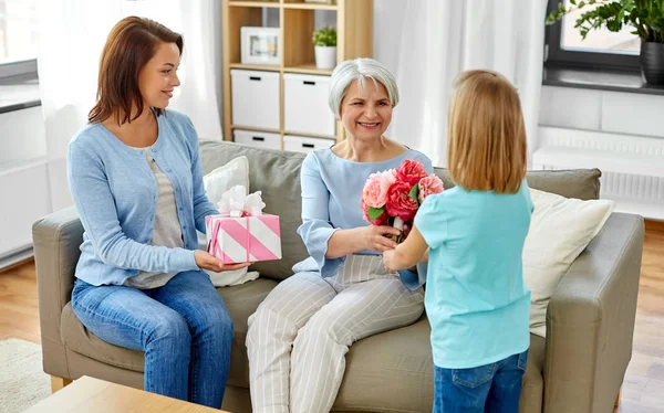 Enkelin schenkt Oma Blumen — Stockfoto