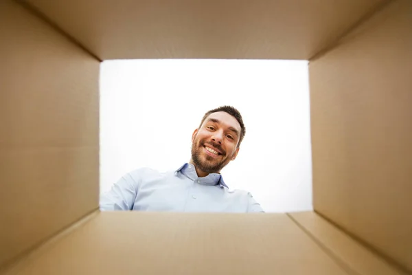 Man looking into open parcel box — Stock Photo, Image