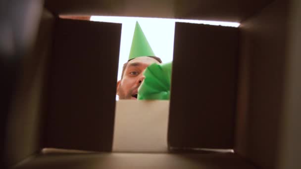 Чоловік відкриває подарункову коробку на день народження зі смартфоном — стокове відео