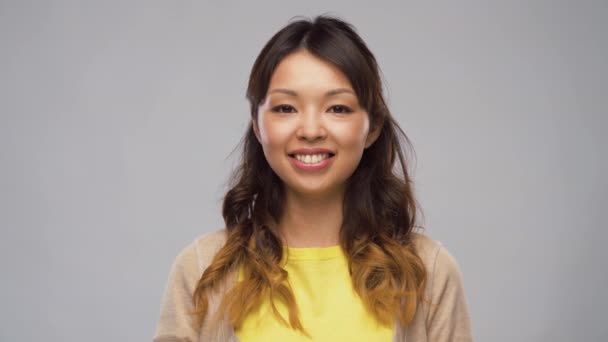 Портрет улыбающейся азиатки, трогающей волосы — стоковое видео