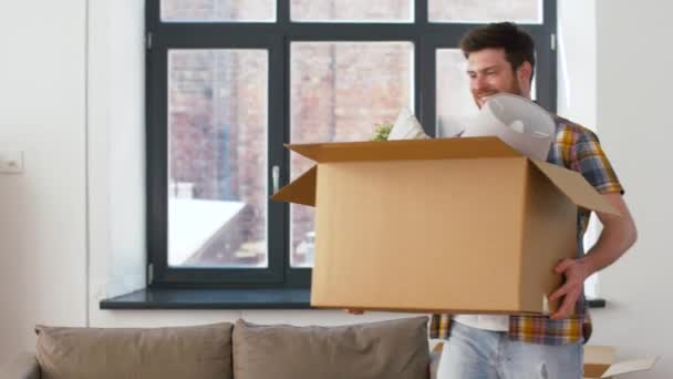 Hombre feliz con la caja de mudanza a nuevo hogar — Vídeo de stock