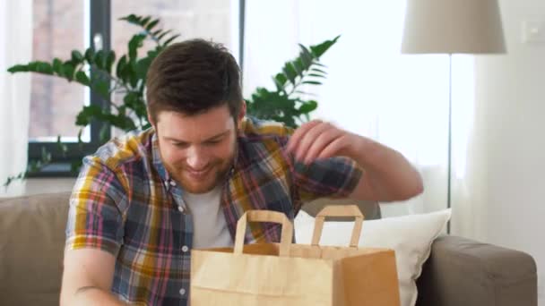 Homem desembalar e comer comida takeaway em casa — Vídeo de Stock