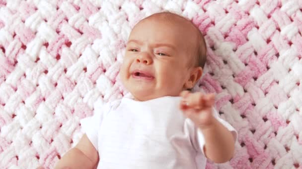 ニットのぬいぐるみ毛布の上に横たわっている泣く女の赤ちゃん — ストック動画