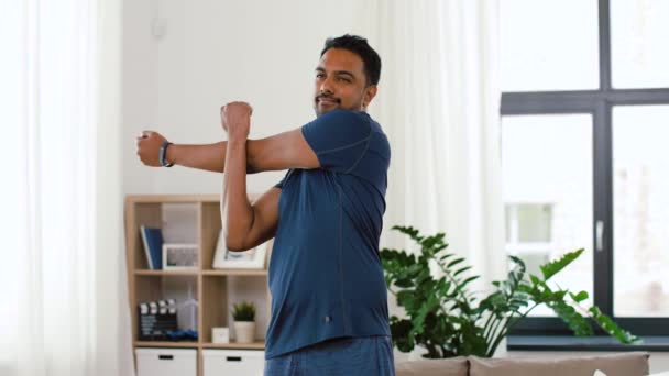 Man med Fitness Tracker stretching kropp hemma — Stockvideo