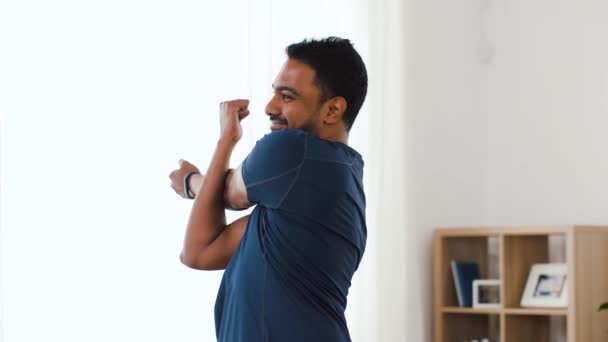 Homem com rastreador de fitness alongamento corpo em casa — Vídeo de Stock