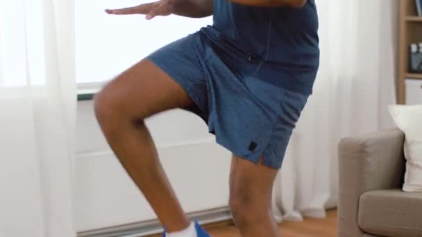 Afro-americano homem pulando no local em casa — Vídeo de Stock