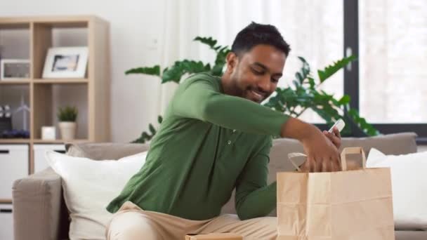 Indio hombre chequeo comida para llevar orden en casa — Vídeos de Stock