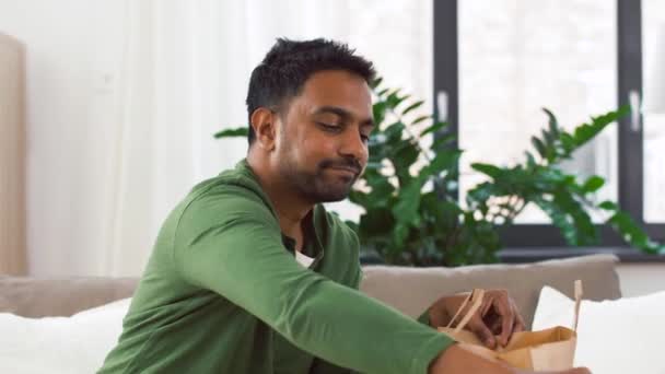 Hombre indio sonriente desempacando comida para llevar en casa — Vídeos de Stock