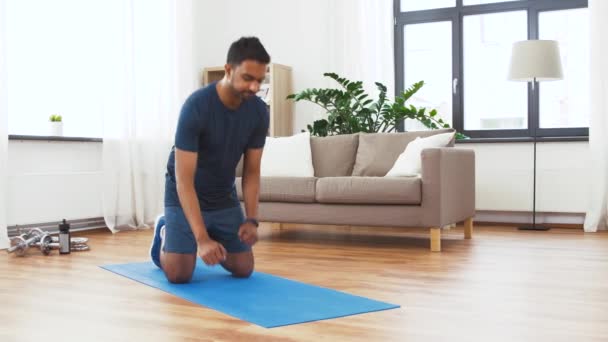 Homme avec tracker de fitness faisant planche à la maison — Video