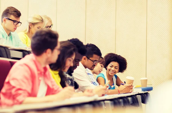 Grupp studenter med kaffe skriva på föreläsning — Stockfoto