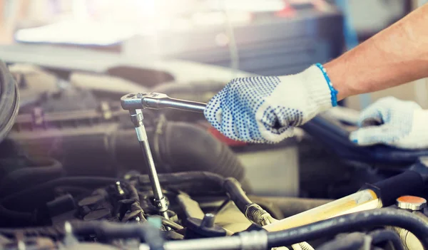 Meccanico con chiave inglese che ripara auto in officina — Foto Stock