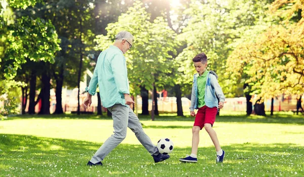 Velho homem e menino jogando futebol no parque de verão — Fotografia de Stock