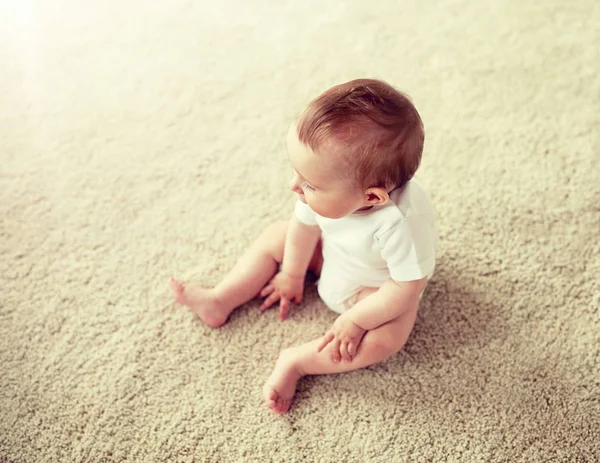 Niño o niña feliz sentado en el suelo en casa —  Fotos de Stock