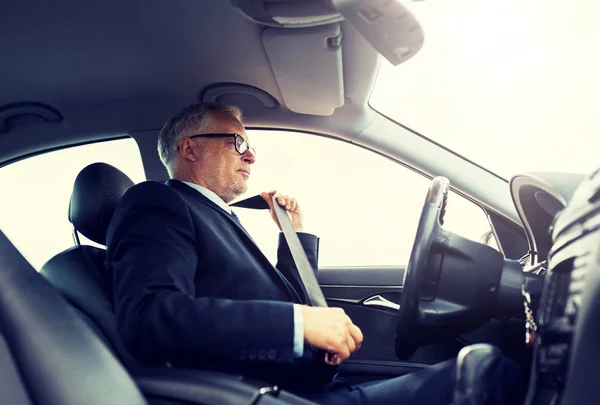 Старший бизнесмен пристегивание ремней безопасности автомобиля — стоковое фото
