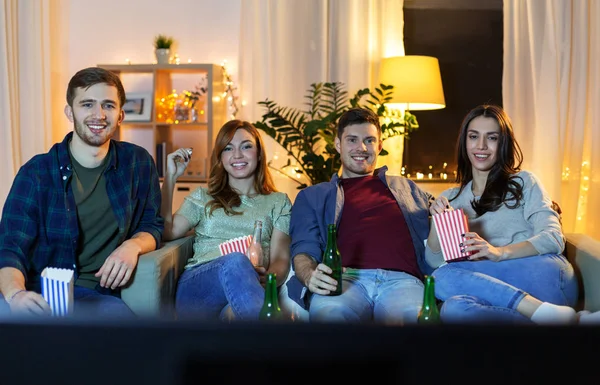 Przyjaciele z piwem i popcornem oglądający telewizję w domu — Zdjęcie stockowe