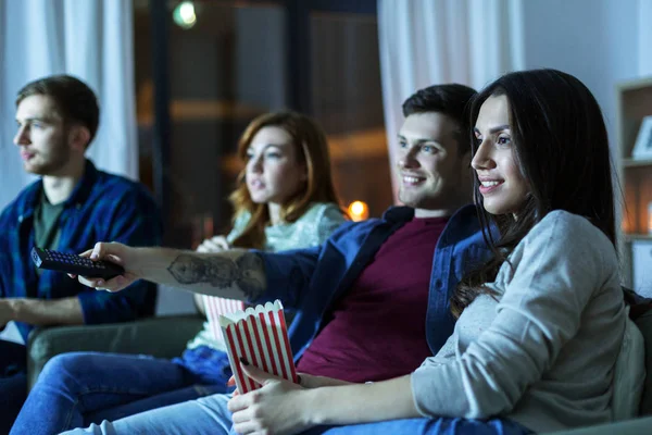 Друзі з попкорном дивитися телевізор вдома — стокове фото