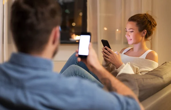 Pareja con smartphones en casa por la noche —  Fotos de Stock