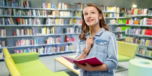 Adolescente estudante menina com notebook na biblioteca — Fotografia de Stock