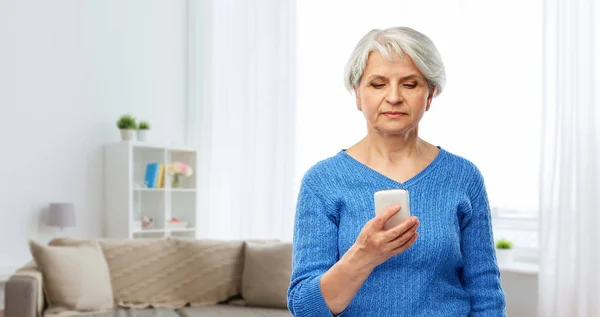 Senior vrouw met behulp van Smartphone thuis — Stockfoto