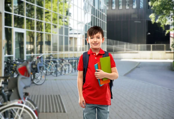 Χαμογελαστός μαθητής με βιβλία και σχολική τσάντα — Φωτογραφία Αρχείου