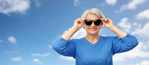 Mujer mayor sonriente en gafas de sol negras —  Fotos de Stock